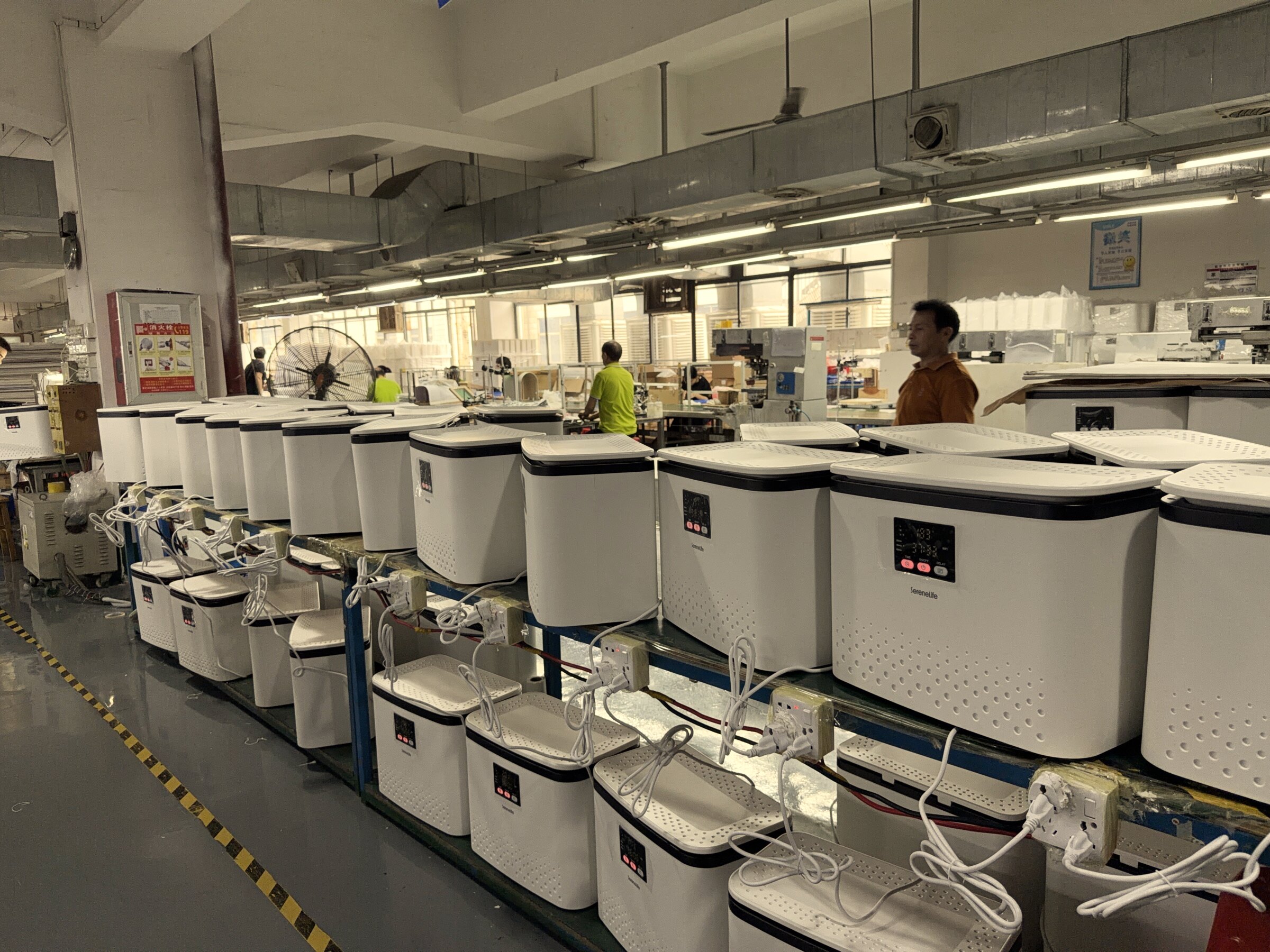 The GoldHot electric towel warmer production line end to end — finished bucket-style units lined up at the QC station before final inspection